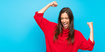 Une femme levant les bras de joie comme après une victoire